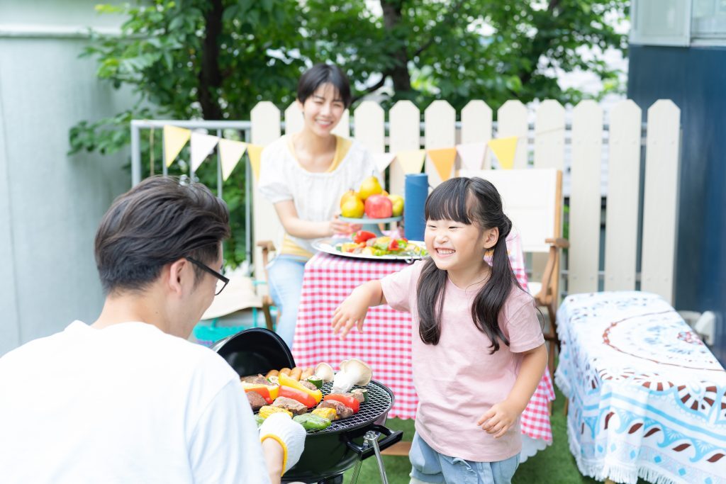庭でBBQを楽しむ親子